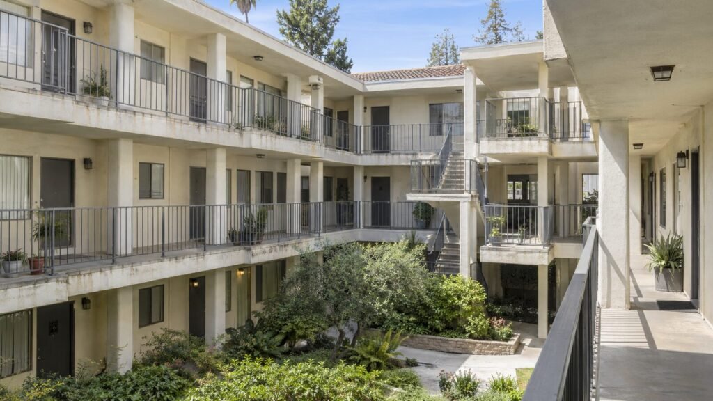 Three-story apartment courtyard with open walkways, railings and an exterior stair covered by SB 721 inspection