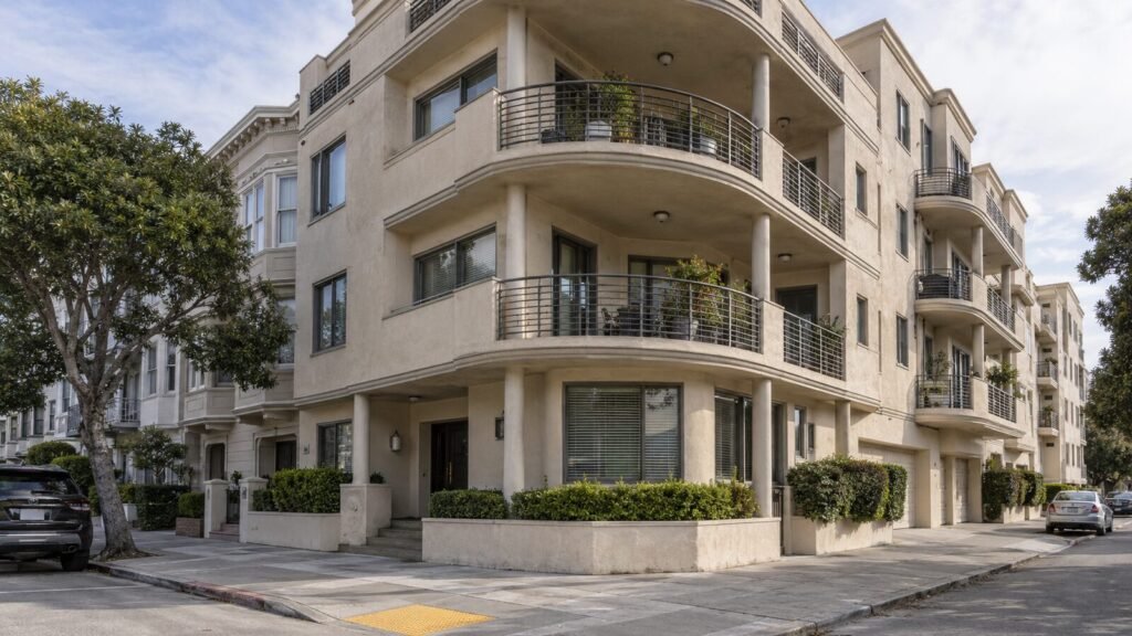 Curved balconies on a four-story San Francisco condo building beside Edwardian row houses, subject to Section 604 inspection