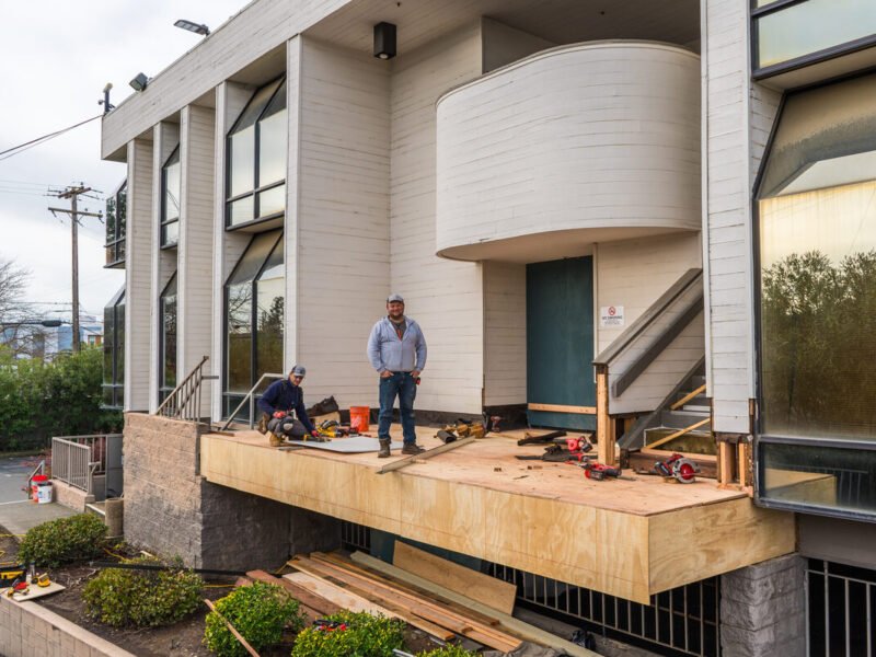 Decks and Balcony team performing deck reconstruction on a multi-story building