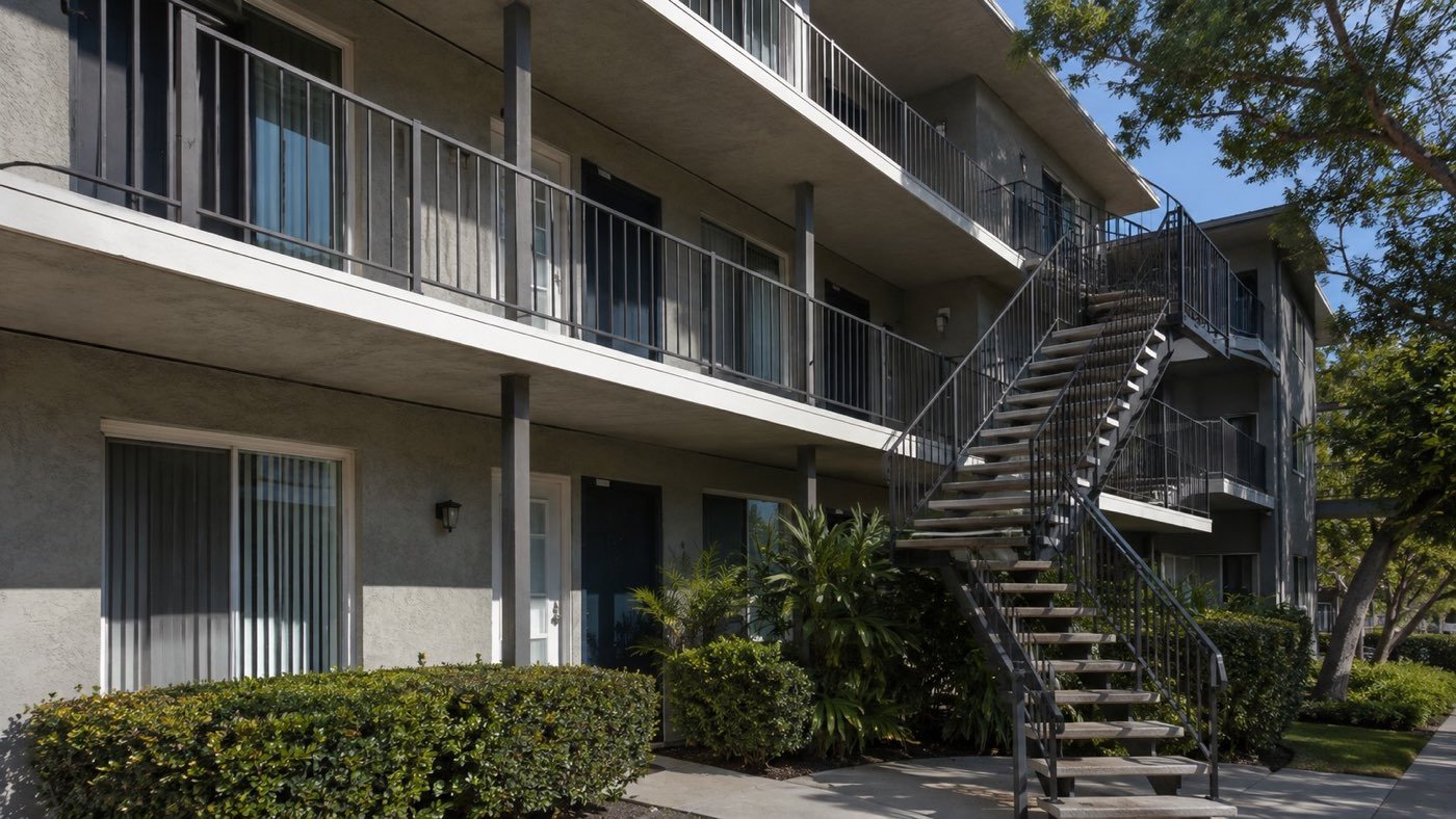 Apartment balconies with metal guard rails and an exterior stairway, covered by California’s multifamily inspection laws