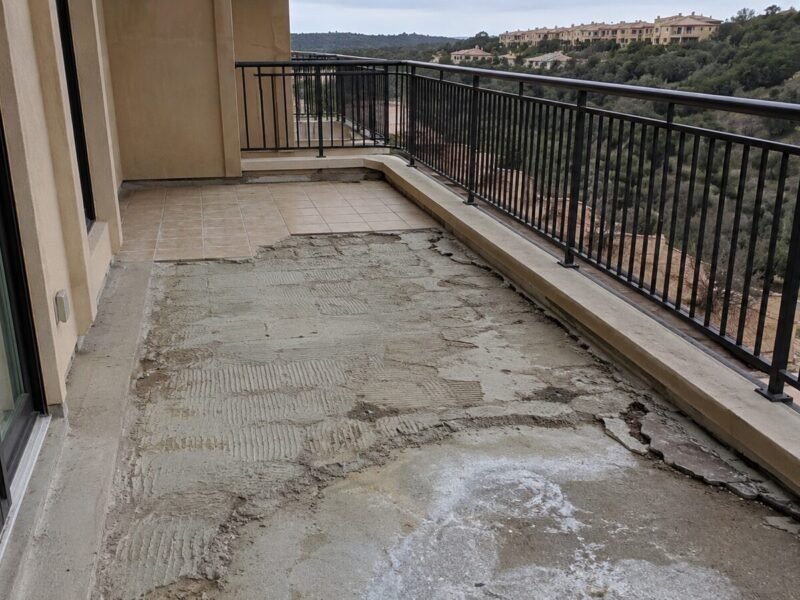 Hillside condominium balcony with tile removed, showing a failed setting bed