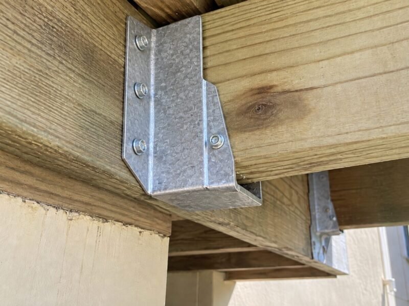 Replaced hot-dip galvanized hanger rated for treated lumber at the balcony ledger