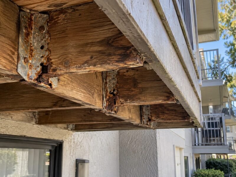 Corroded joist hangers exposed beneath an apartment balcony during an SB 721 inspection in Hayward, CA