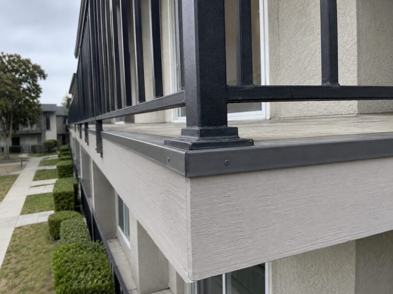 Rebuilt balcony perimeter with new guardrail posts set on flashed blocking