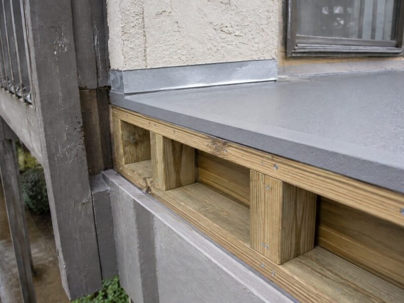 New pressure-treated ledger blocking with galvanized flashing installed