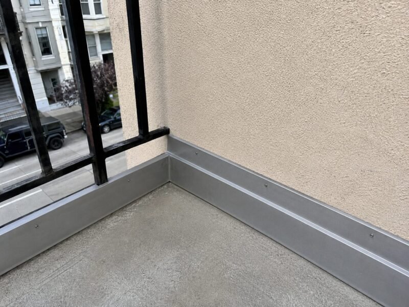 New sheet-metal ledger flashing installed on a SoMa apartment balcony