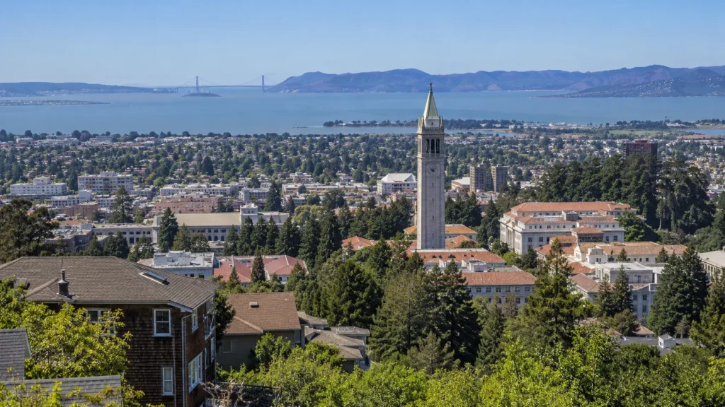 Sather Tower and the UC Berkeley campus above Berkeley neighborhoods, with San Francisco Bay and the Golden Gate Bridge in the distance